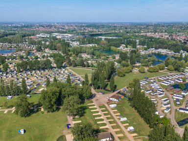 An aerial view of a holiday park with rows of caravans trees and water bodies at Lakeside Lullaby - Billing Aquadrome