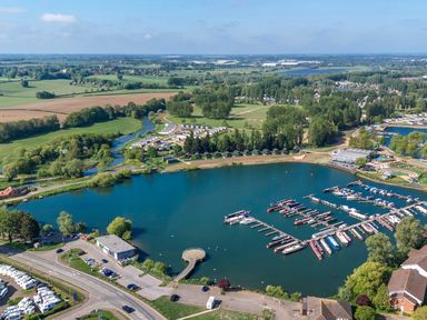 An aerial view of a marina with boats docked and surrounding green fields at Moonlit Skylight - Billing Aquadrome Holiday Park