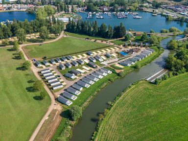 An aerial view of a holiday park with rows of caravans near a river and a marina at Willowbrook Hideaway Billing Aquadrome