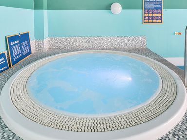 A spa area with a round spa and signs at Island Breeze - Hayling Island