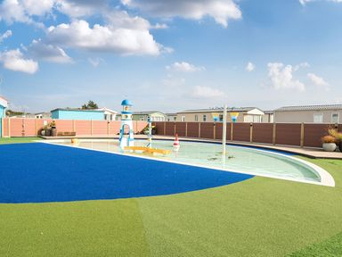 An outdoor swimming pool with play equipment at Wave Whisperers - Hayling Island