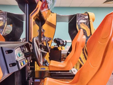 An arcade machine with a steering wheel and seat at Golden Dune - Hayling Island