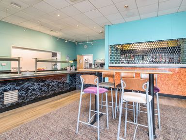 A dining area with bar stools and a serving counter at Golden Dune - Hayling Island