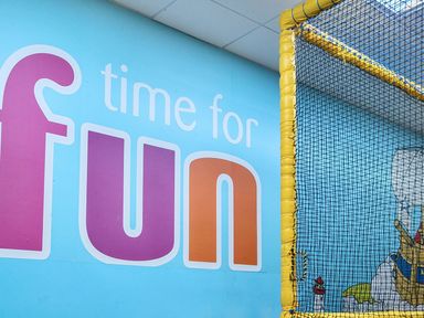 A play area with a wall that says 'time for fun' and netting at Golden Dune - Hayling Island