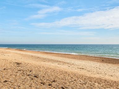 A beach with sand and ocean waves at The Lookout - Hayling Island