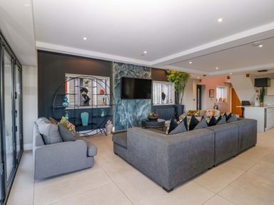 A living room with a sofa and television at Forest Lodge in Pontyclun