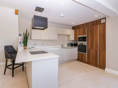 A kitchen with an island and appliances at Forest Lodge in Pontyclun
