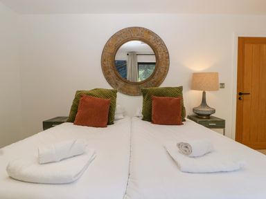 A bedroom with two beds and a lamp at Forest Lodge in Pontyclun