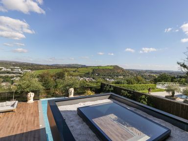 An outdoor area with spa pool and furniture at Forest Lodge in Pontyclun