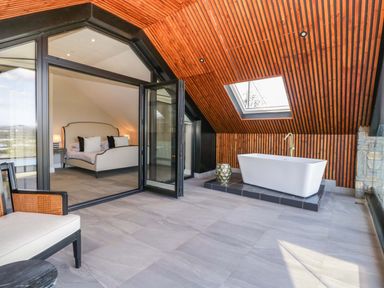 A bedroom with a bath and a bed at Forest Lodge Pontyclun
