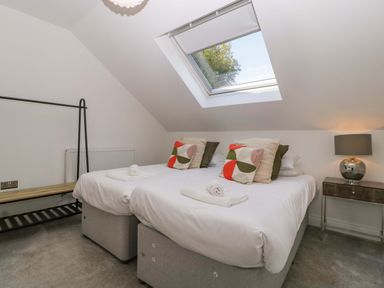 A bedroom with two beds and a skylight at Forest Lodge in Pontyclun