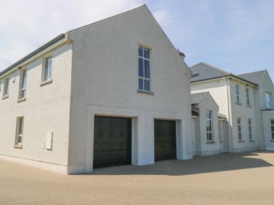 An exterior view of a house with garage doors at The East Wing Apartment in Claremorris