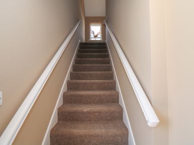 A staircase with carpet and a window at The East Wing Apartment in Claremorris