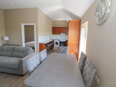 A living room area with a sofa and dining table at The East Wing Apartment in Claremorris