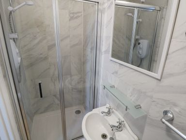 A shower and sink in a bathroom at The East Wing Apartment Claremorris