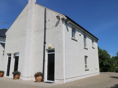 A building with windows and flower pots at The East Wing Apartment Claremorris