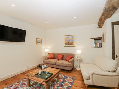 A living room with a television and sofa at Stable cottage Sopworth near Sherston