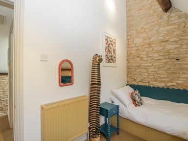 A bedroom with a bed and decorative items at Stable cottage Sopworth near Sherston