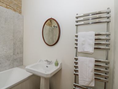 A bathroom with a sink and a bathtub at Stable cottage Sopworth near Sherston