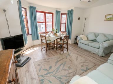 A living room with a table set for dining at Flat 9 in Swanage