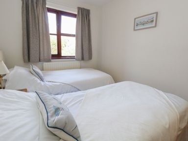 A bedroom with two beds and a window at Flat 9 in Swanage