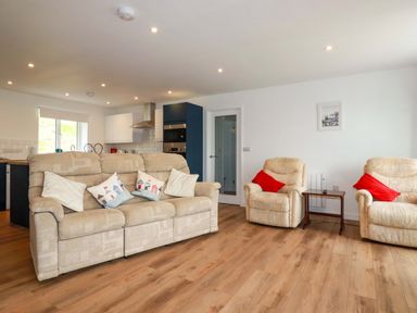 A living room with a sofa and armchairs at Folly View in Cambrose near Illogan