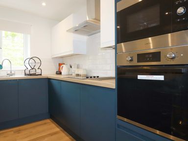 A kitchen with a sink, kettle, microwave and oven at Folly View in Cambrose near Illogan
