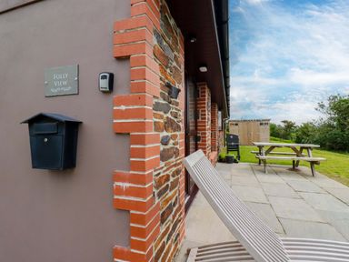 An outdoor area with a bench and grill at Folly View Cambrose near Illogan