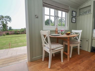 A dining area with a table and chairs at Shepherd's Hut in Wrexham