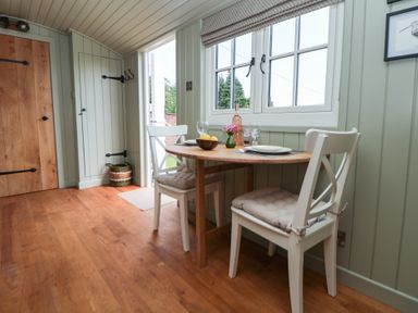 A dining room with a table and chairs at Shepherd's Hut in Wrexham