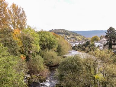 A view of a river surrounded by trees and hills at The Garden Hut in Wrexham