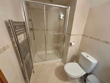 A bathroom with a shower, toilet and towel radiator at Acorn Lodge Finlakes Holiday Park near Chudleigh