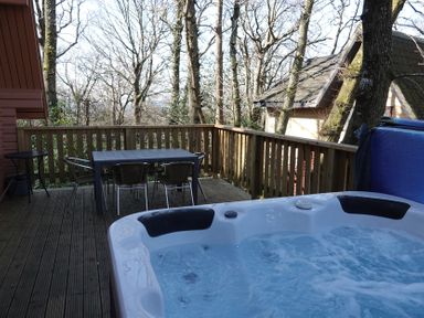 An outdoor space with a hot tub and dining furniture at Acorn Lodge Finlakes Holiday Park near Chudleigh