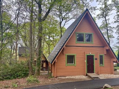 A cabin surrounded by trees at Acorn Lodge Finlakes Holiday Park near Chudleigh