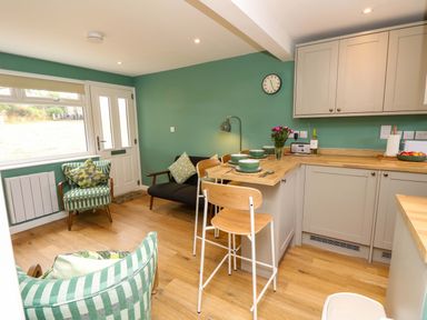 A kitchen with a table and chairs at No 157 Sandown Bay Holiday Chalet 'Field View' Sandown