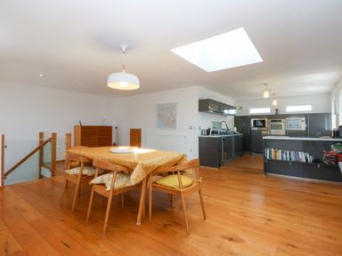 A dining area with a table and chairs in an open kitchen at Shearwater Rhosneigr