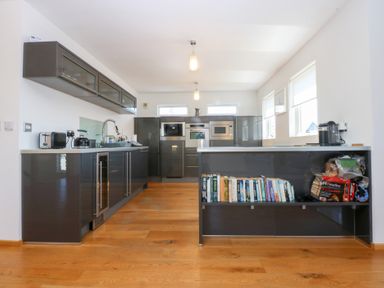 A kitchen with cupboards, sink, and appliances at Shearwater in Rhosneigr