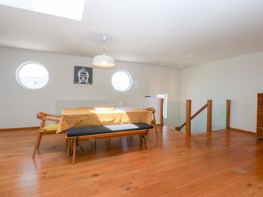 A dining room with circular windows and a table at Shearwater in Rhosneigr
