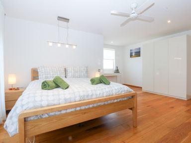 A bedroom with a bed and wardrobe at Shearwater in Rhosneigr