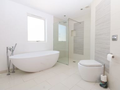 A bathroom featuring a bathtub, shower, and toilet at Shearwater in Rhosneigr