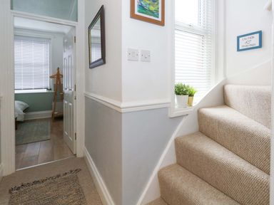 A hallway with stairs and a mirror at Seagull & Chips in Weymouth