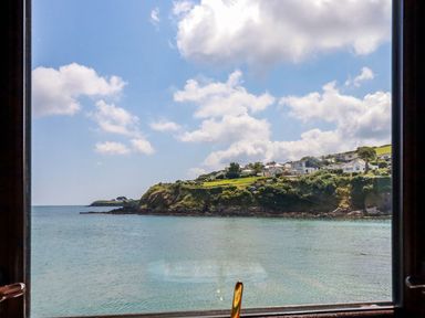 View of a coastal landscape with houses on a hill overlooking the sea at Rock Cottage Portmellon near Mevagissey