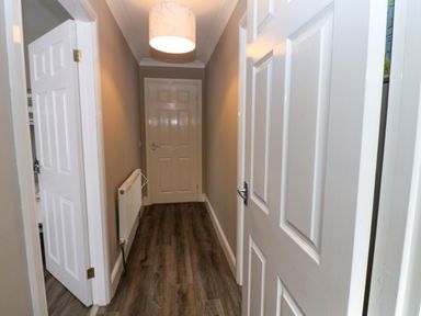 A hallway with doors and a ceiling light at Amblers Rest in Amble