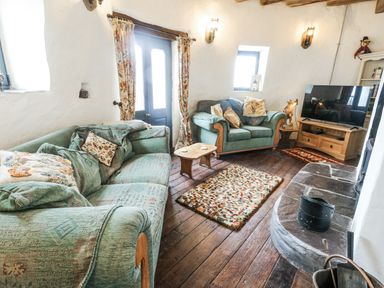 A living room with sofas and a television at The Old Cornmill in Cemaes Bay