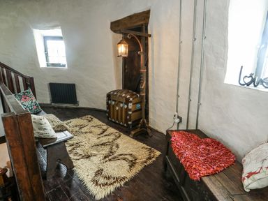 A snug area with a chest and seating at The Old Cornmill in Cemaes Bay