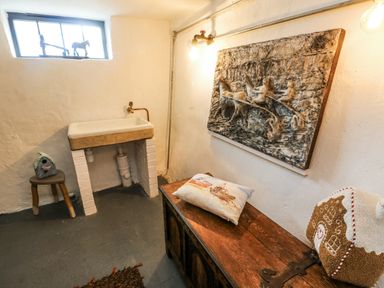 A utility room with a sink and artwork at The Old Cornmill in Cemaes Bay