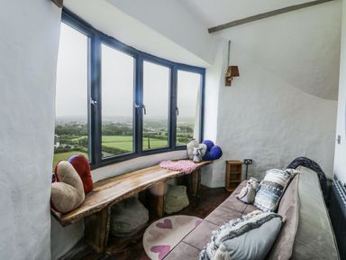 A sitting room with a view and a wooden bench at The Old Cornmill in Cemaes Bay