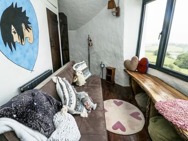 A snug with a sofa and wall art at The Old Cornmill in Cemaes Bay