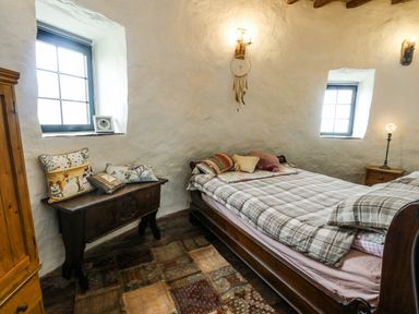 A bedroom with a bed and window at The Old Cornmill in Cemaes Bay