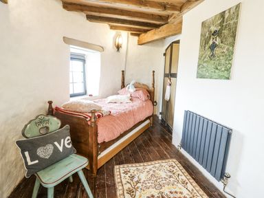 A bedroom with a bed and artwork at The Old Cornmill in Cemaes Bay